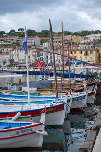 Boats moored in harbor against sky