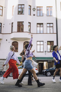 Young lgbtqia friends walking on footpath during gay pride parade