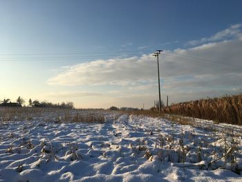 Snow covered field against sky