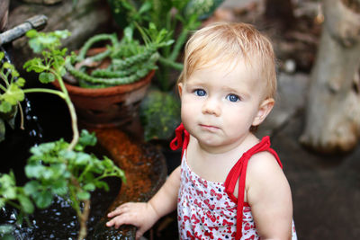 Portrait of cute baby girl standing by pond