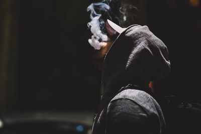 Rear view of man standing against black background