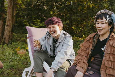 Portrait of smiling friends sitting in tent