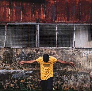 Rear view of man standing against wall