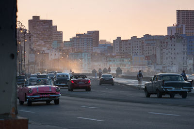 Cars on road in city during sunset