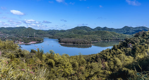 Scenic view of lake and mountains against blue sky