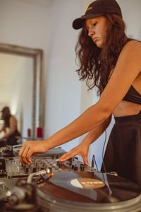 Fashionable young woman playing music at home