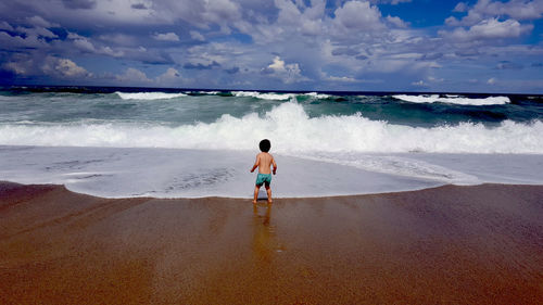 Rear view of boy on beach