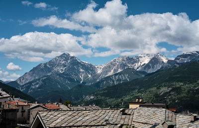 Houses on snowcapped mountain against sky