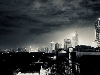 Illuminated buildings in city against sky