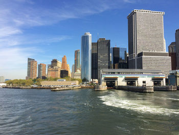 City skyline by river against sky