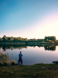 Man standing by lake against sky