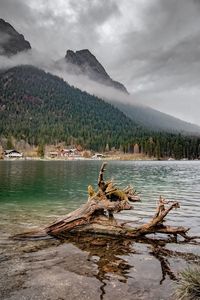 Scenic view of lake by mountains against sky