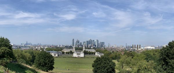 Panoramic view of trees and buildings against sky