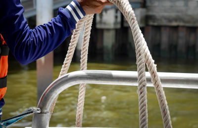 Low angle view of man holding rope in playground