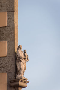 Low angle view of statue against clear sky. low angle view of madonna and jesus statues against sky 