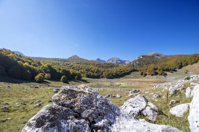 Scenic view of rocky mountains against clear blue sky