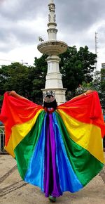 Multi colored flags against rainbow in sky