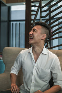 Laughing man sitting on sofa