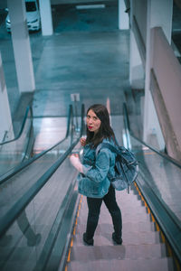 Full length of woman standing on railing