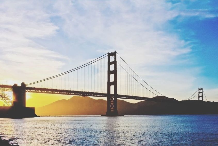 connection, bridge - man made structure, engineering, built structure, suspension bridge, architecture, water, bridge, sky, waterfront, river, transportation, travel destinations, international landmark, famous place, sea, cable-stayed bridge, long, low angle view, tourism