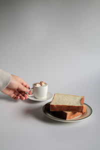 Cropped hand of woman holding coffee on table