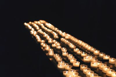 Close-up of illuminated lighting equipment against black background