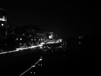 Road passing through illuminated city at night