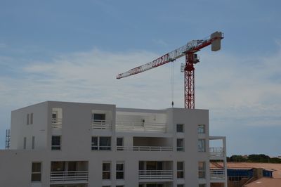 Low angle view of crane against sky