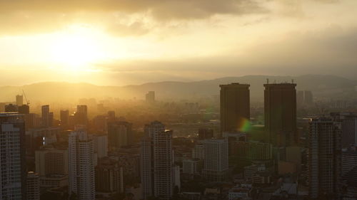 Aerial view of cityscape in foggy weather during sunrise 