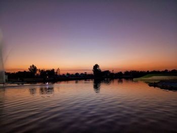 Scenic view of lake against clear sky during sunset