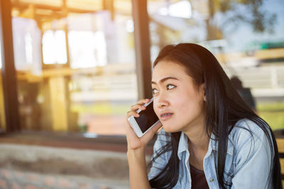 Portrait of young woman using mobile phone