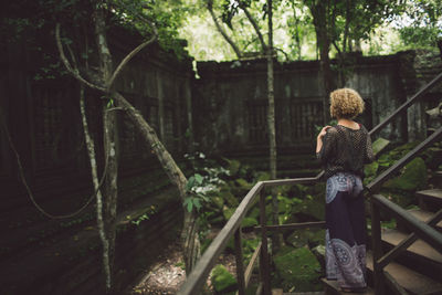 Woman standing on steps against old ruins