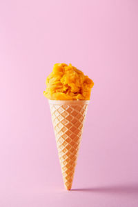 Autumn leaf on ice cream against gray background