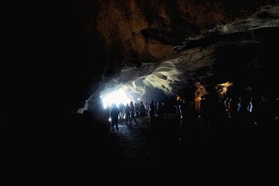 Silhouette people in cave at night