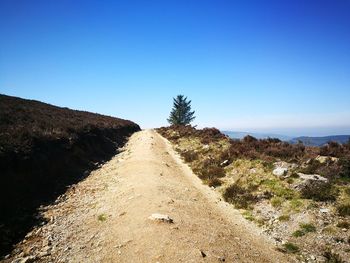 Dirt road against clear blue sky