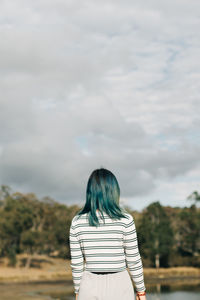 Rear view of woman standing against sky