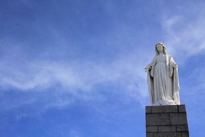 Low angle view of statue against blue sky