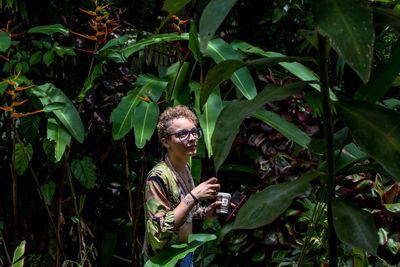 Low angle view of woman standing amidst plants