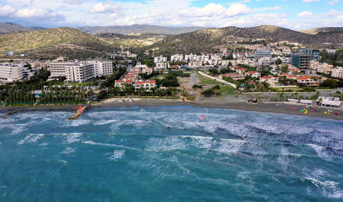 High angle view of townscape by sea against sky