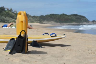 Close-up of yellow toy on beach against sky