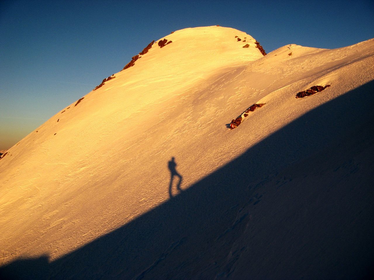 clear sky, sand, shadow, tranquility, sunlight, tranquil scene, nature, scenics, landscape, desert, beauty in nature, sky, outdoors, beach, blue, mountain, walking, low angle view, unrecognizable person