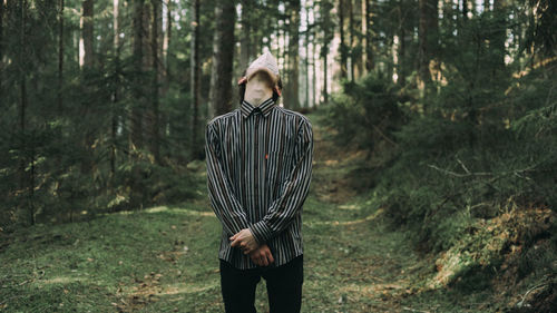 Full length of young woman standing in forest