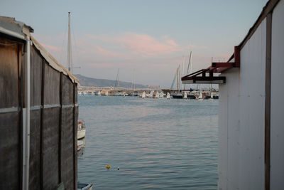 Houses by sea against sky during sunset