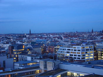 High angle view of illuminated buildings against blue sky