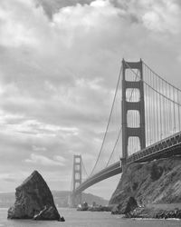 View of suspension bridge against cloudy sky