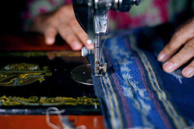 Cropped image of woman using sewing machine