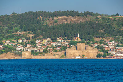 Scenic view of sea by buildings against sky