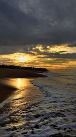 Scenic view of beach against dramatic sky