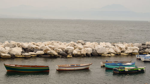 Fishing boats in sea against sky