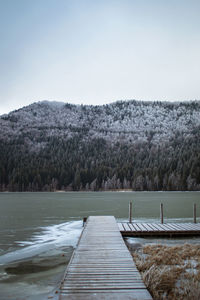 Pier over lake against clear sky